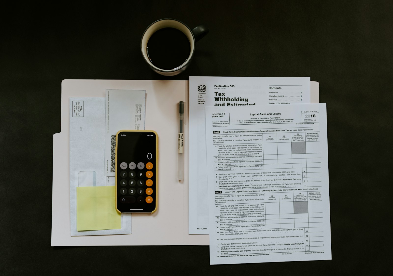 ACA premium tax credit and subsidy paperwork with a folder, phone, and pen